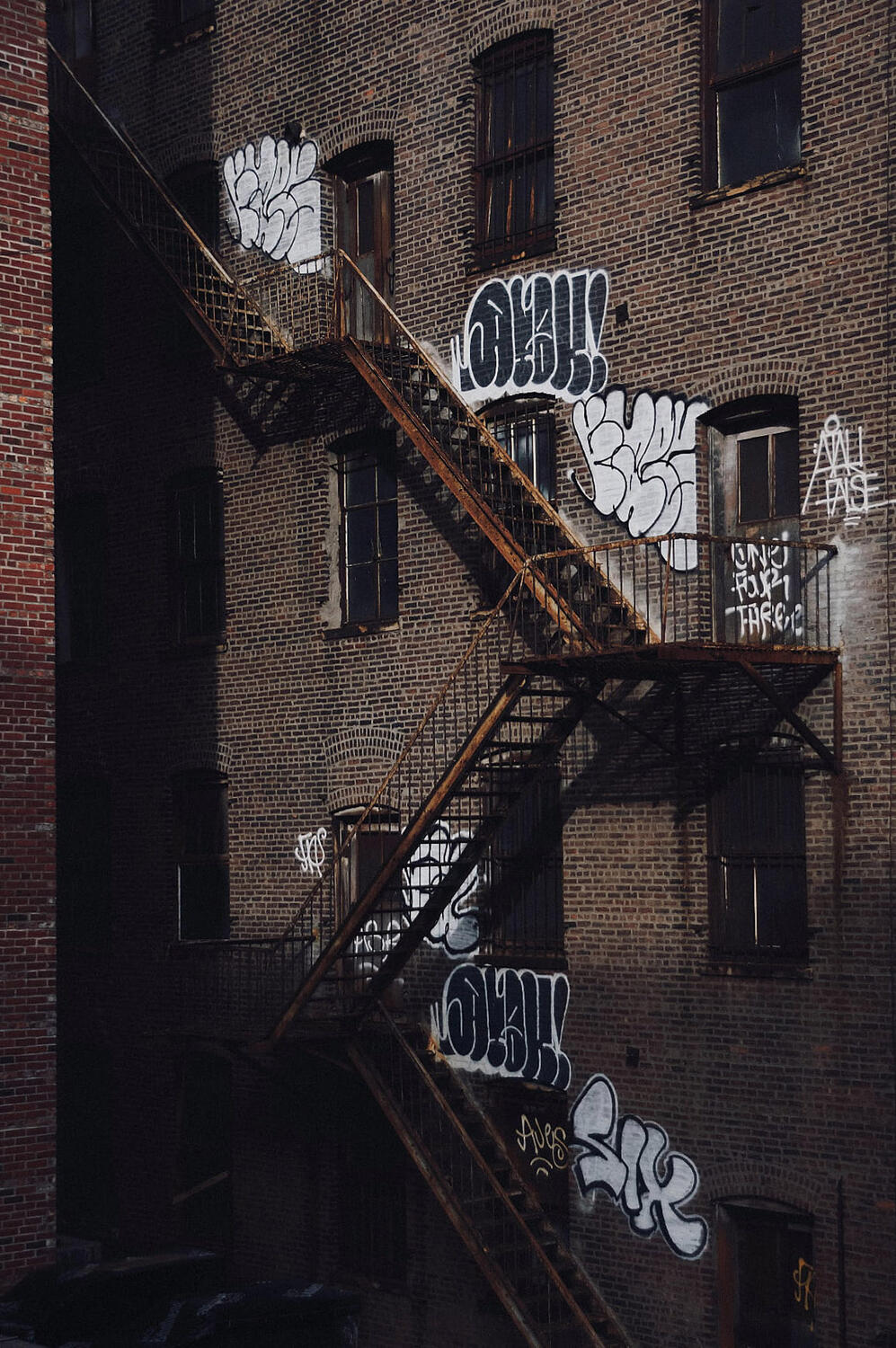 Fire escape staircase with graffiti on the wall